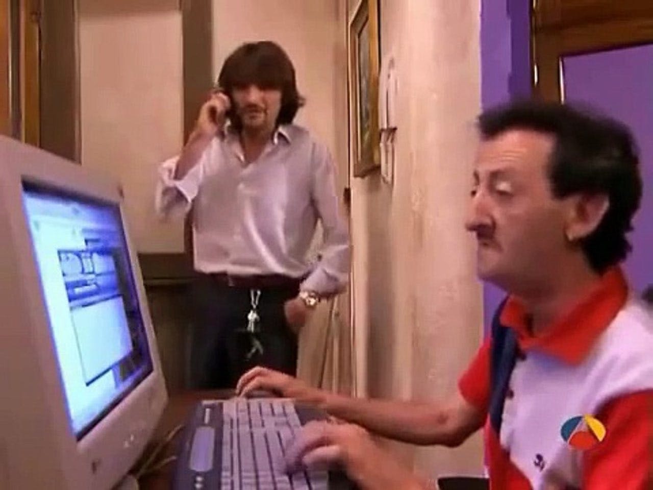 Mariano usando un ordenador mientras Emilio le mira
